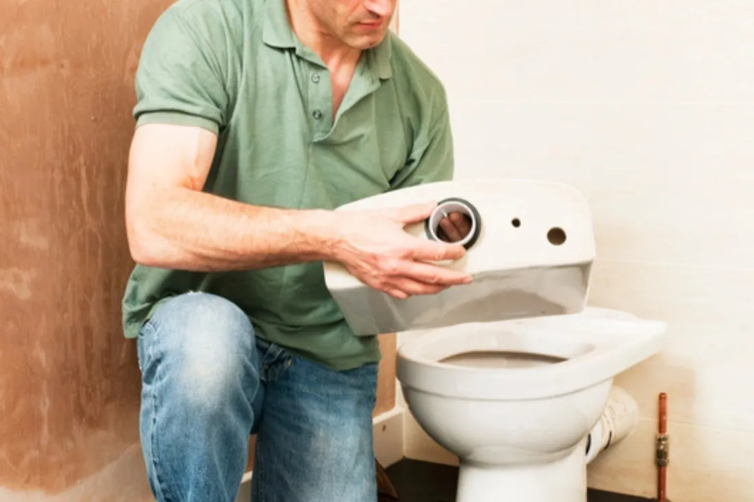 Mand samler ventilerne i en toiletcisterne